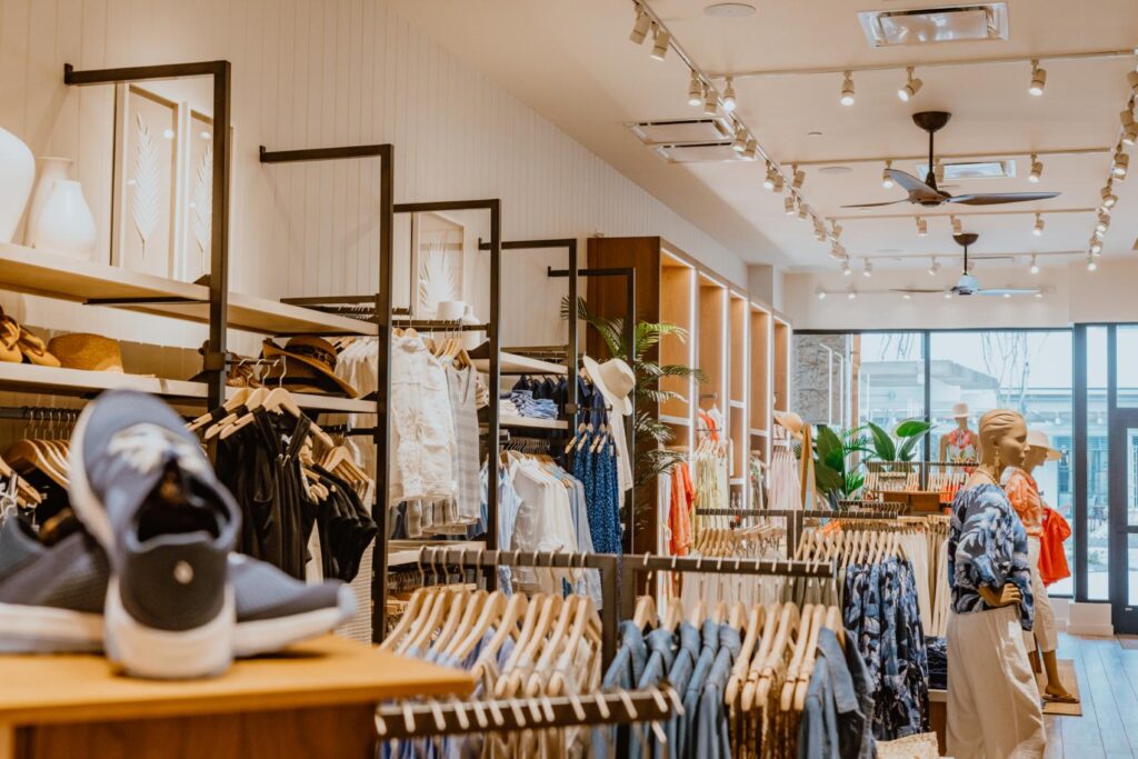 Shoppers browse through a well-organized D Barnes Construction clothing store with a variety of garments on display.